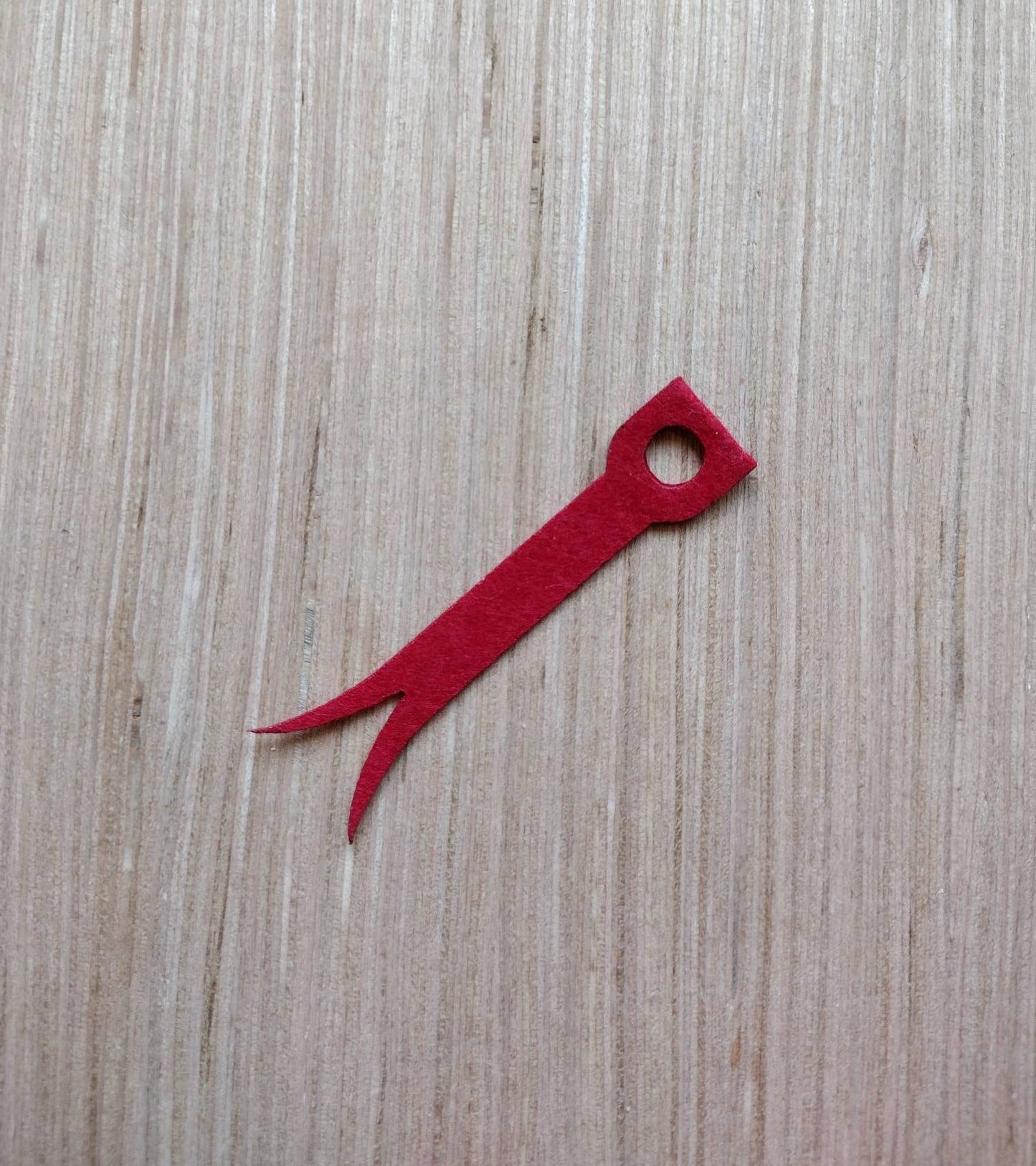 a red pair of scissors sitting on top of a wooden table