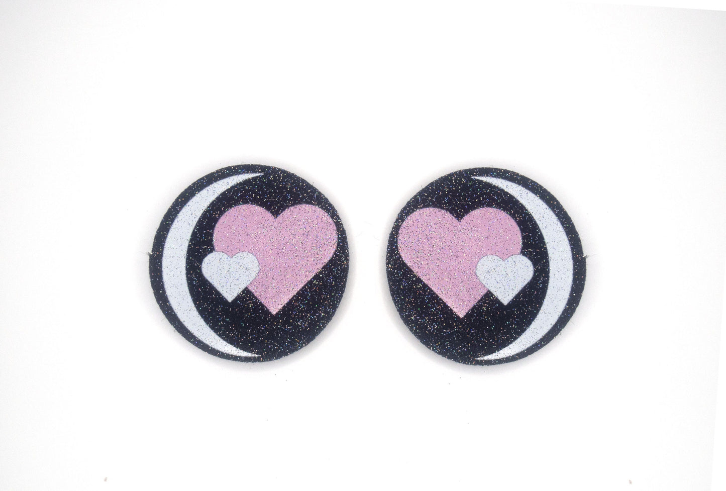 a pair of pink and black heart shaped buttons
