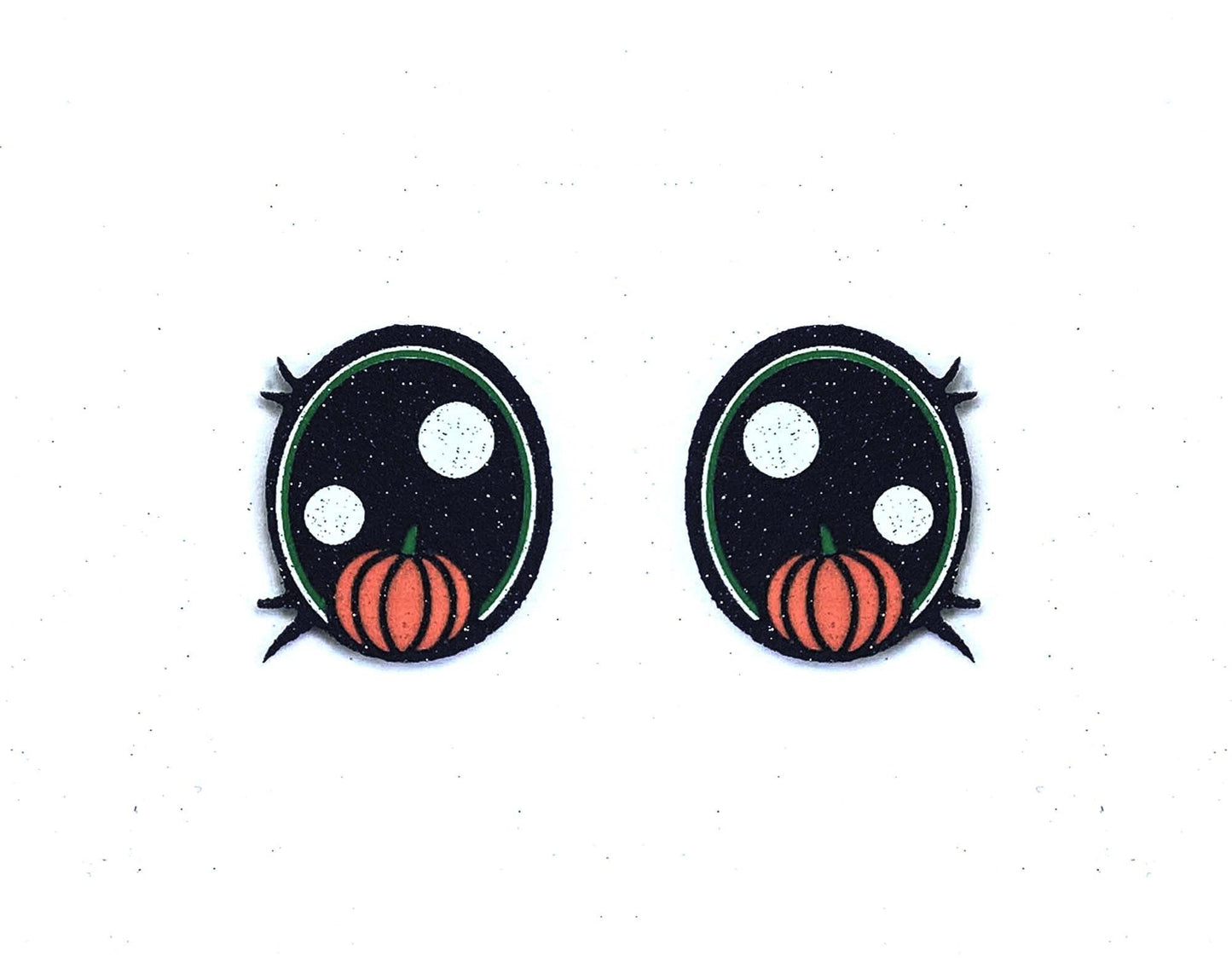 a pair of black and orange pumpkins on a white background