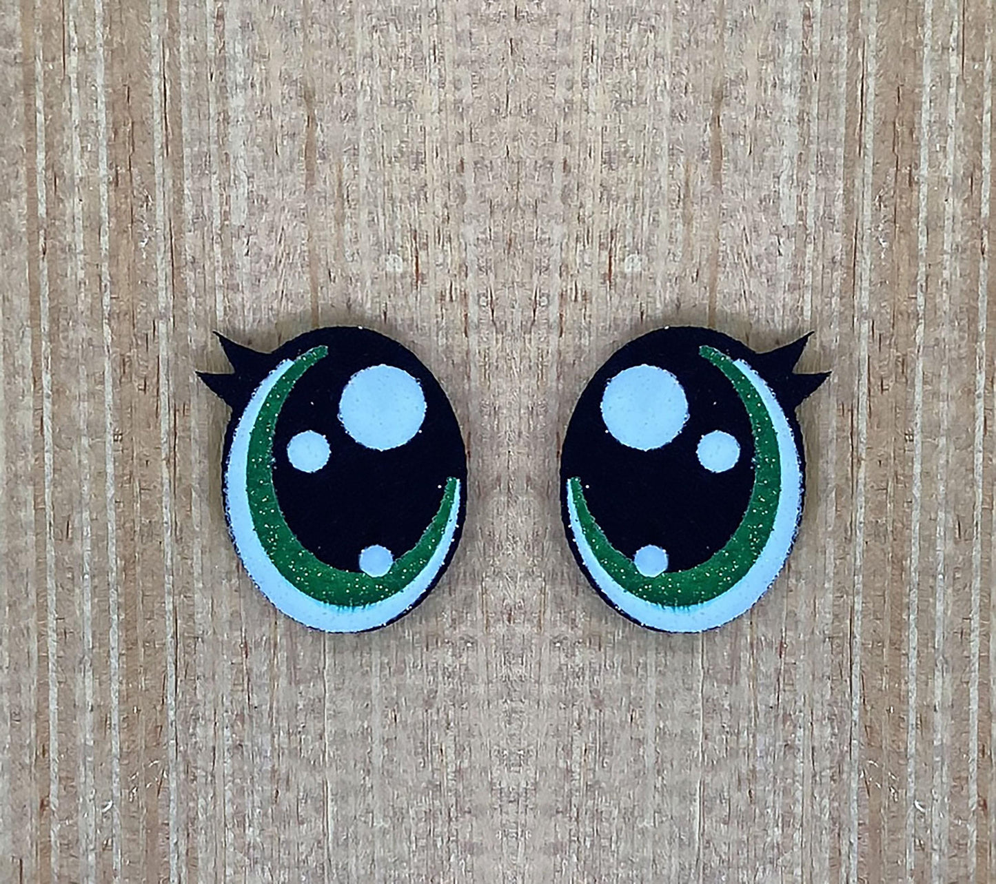 a pair of black and green buttons with white dots
