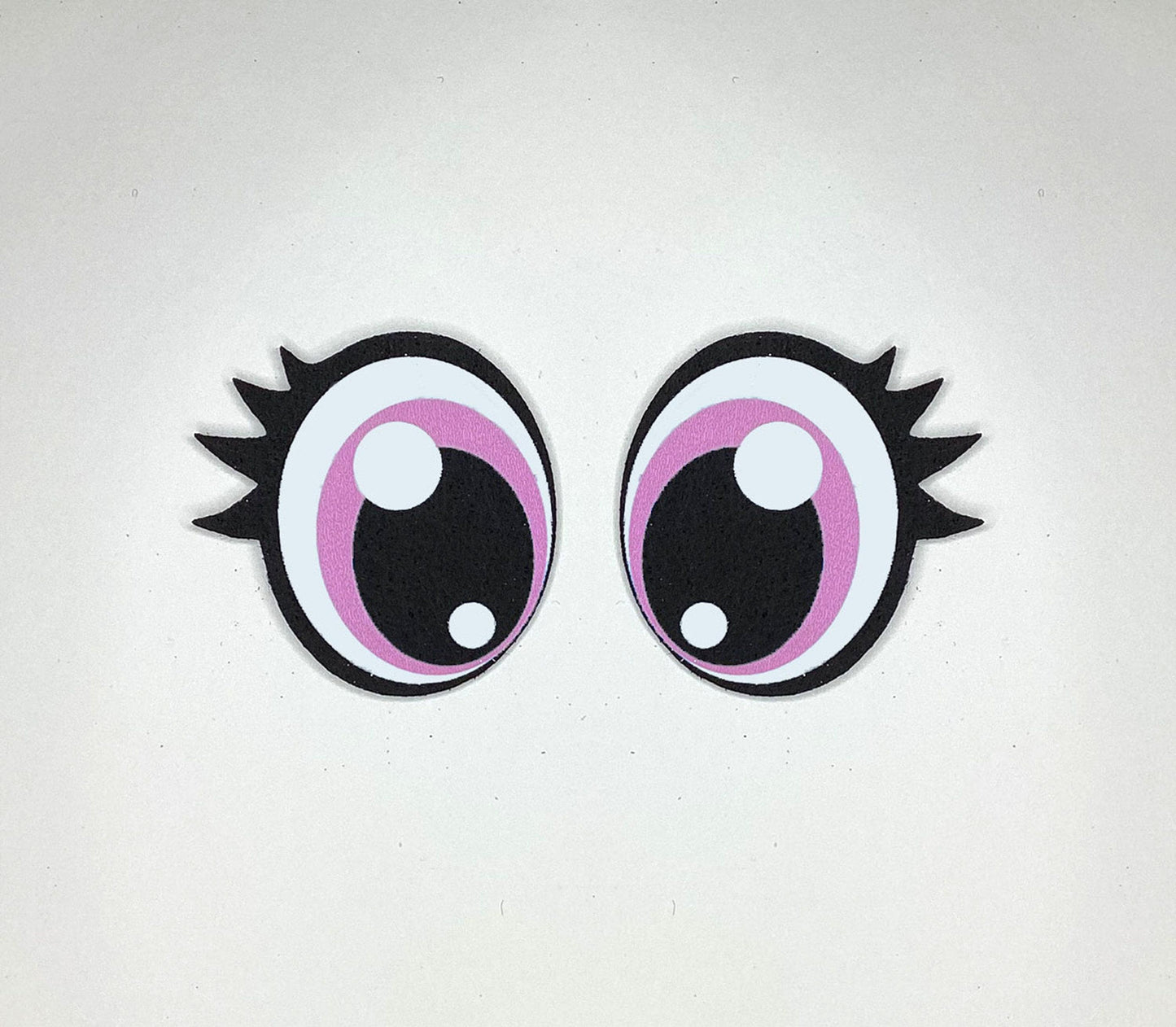 a pair of pink and black eyeballs on a white surface