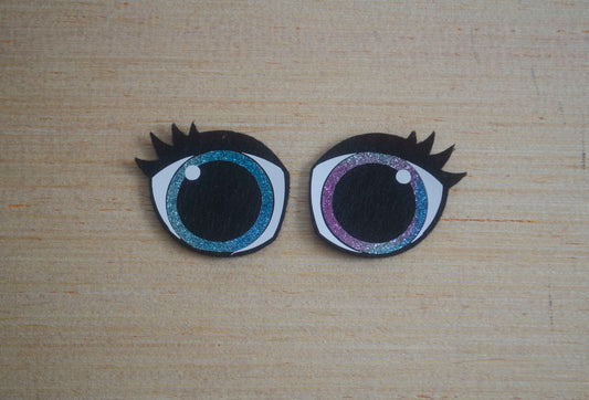 a close up of two fake eyes on a wooden surface