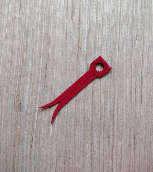 a red pair of scissors sitting on top of a wooden table