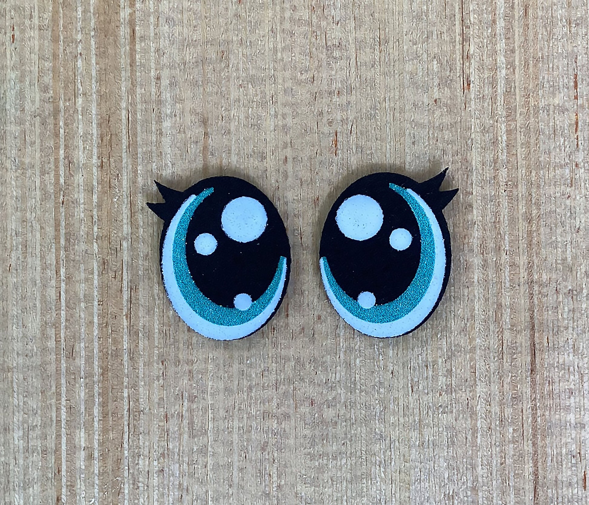a pair of black and white hair clips on a wooden surface