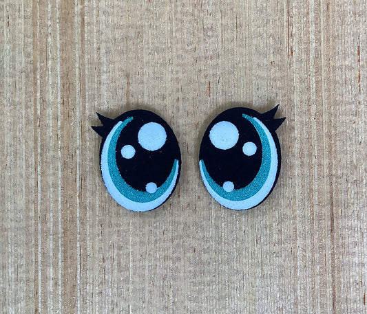 a pair of black and white hair clips on a wooden surface