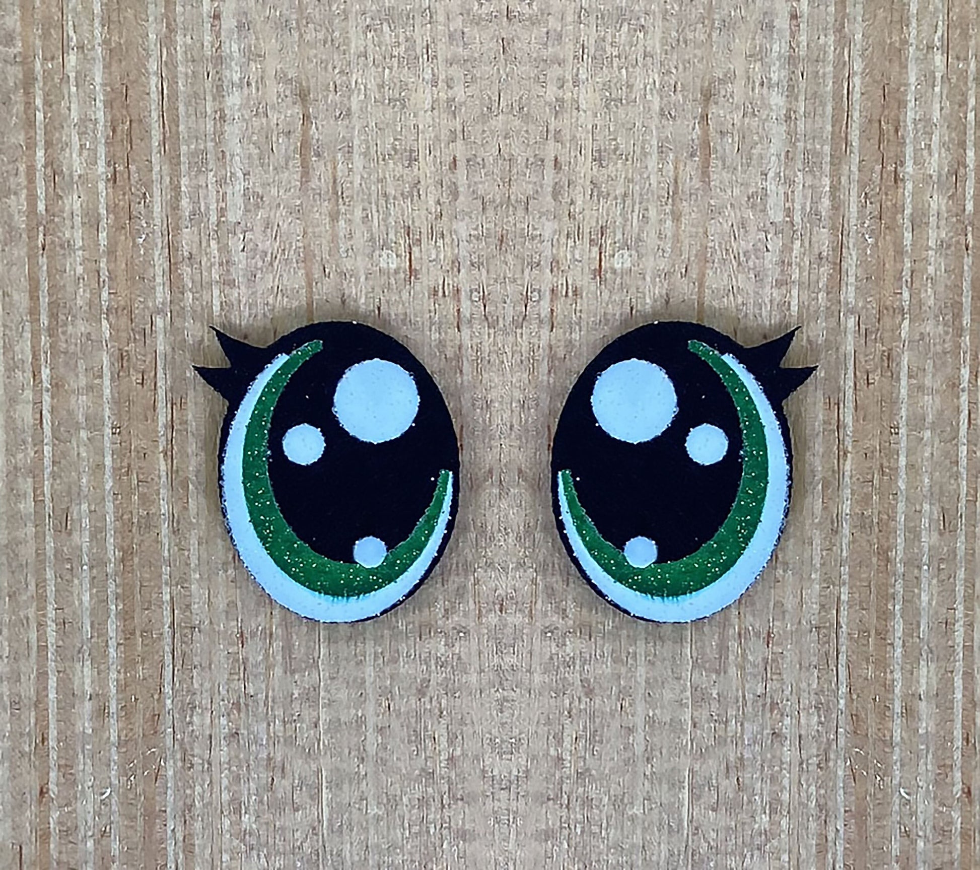a pair of black and green buttons with white dots
