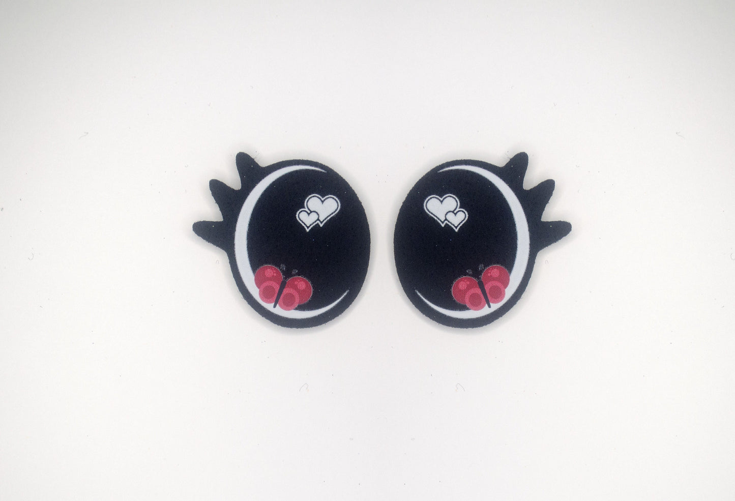 a pair of black and red heart shaped earrings
