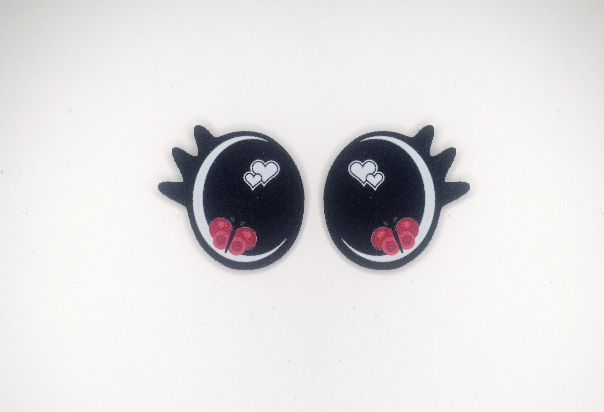 a pair of black and red heart shaped earrings