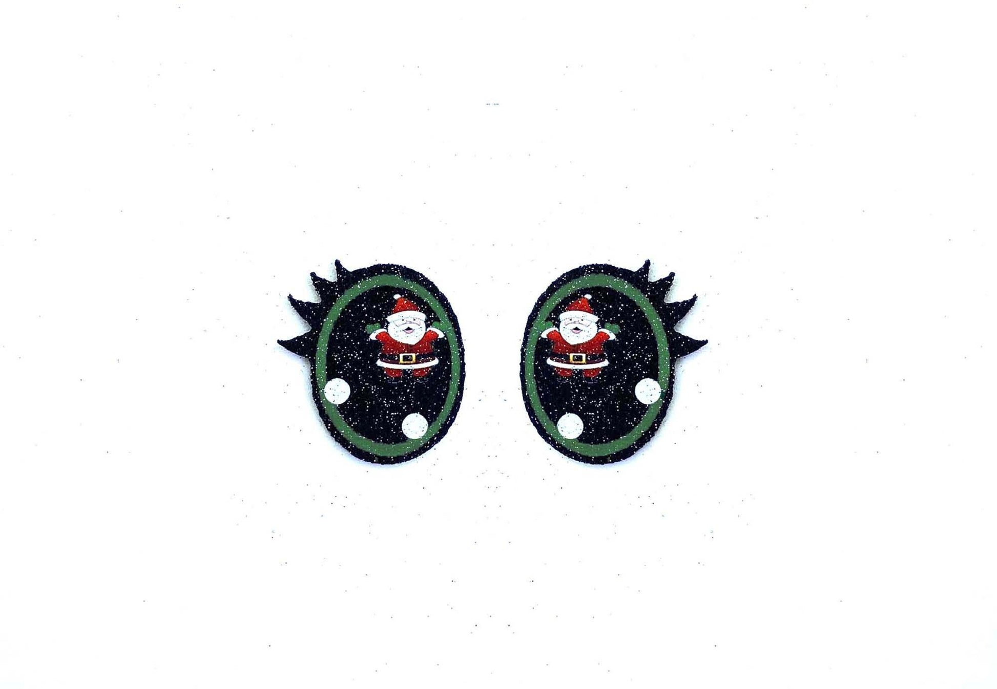 a pair of black and green earrings with a santa clause on it