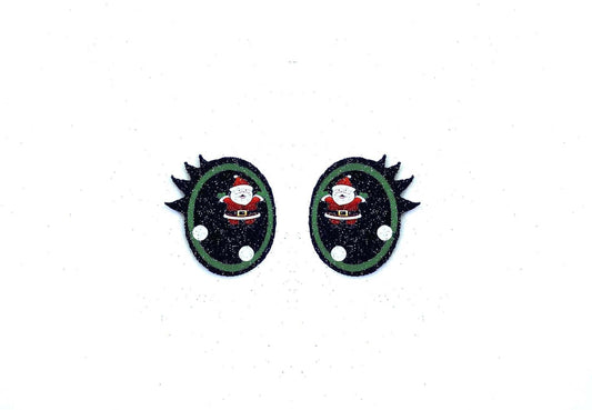 a pair of black and green earrings with a santa clause on it