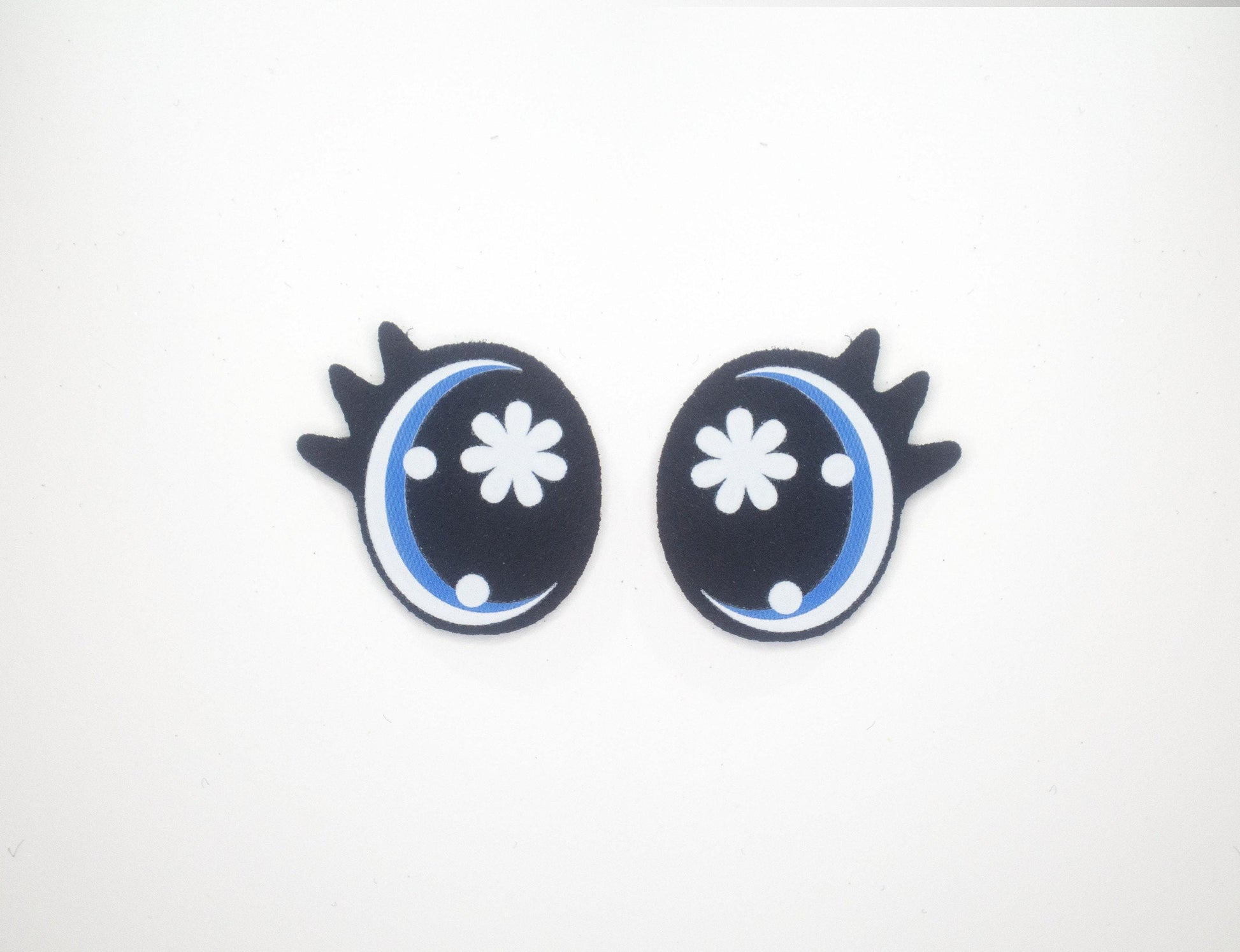 a pair of black and blue earrings on a white background