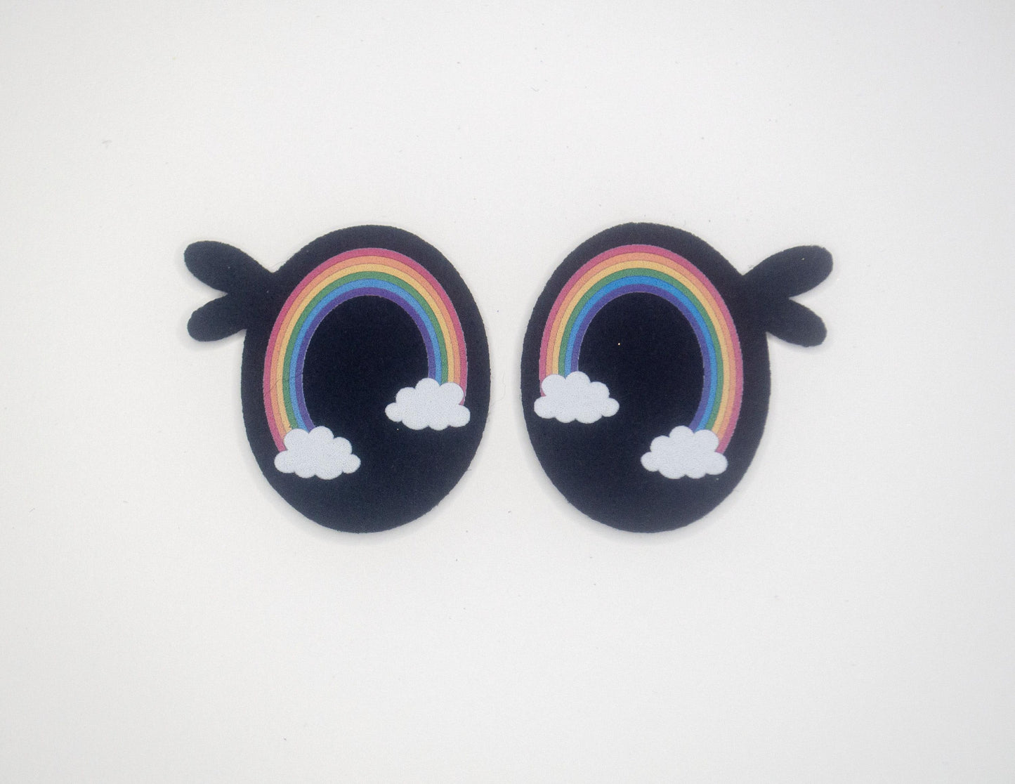 a pair of earrings with a rainbow and clouds on them