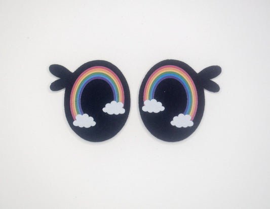 a pair of earrings with a rainbow and clouds on them
