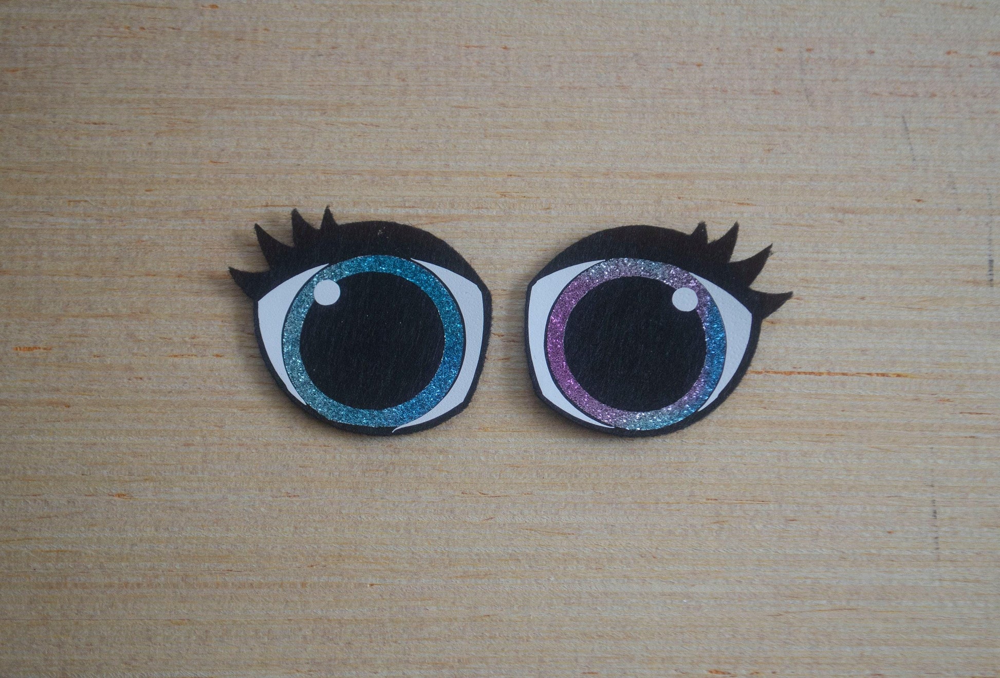 a close up of two fake eyes on a wooden surface