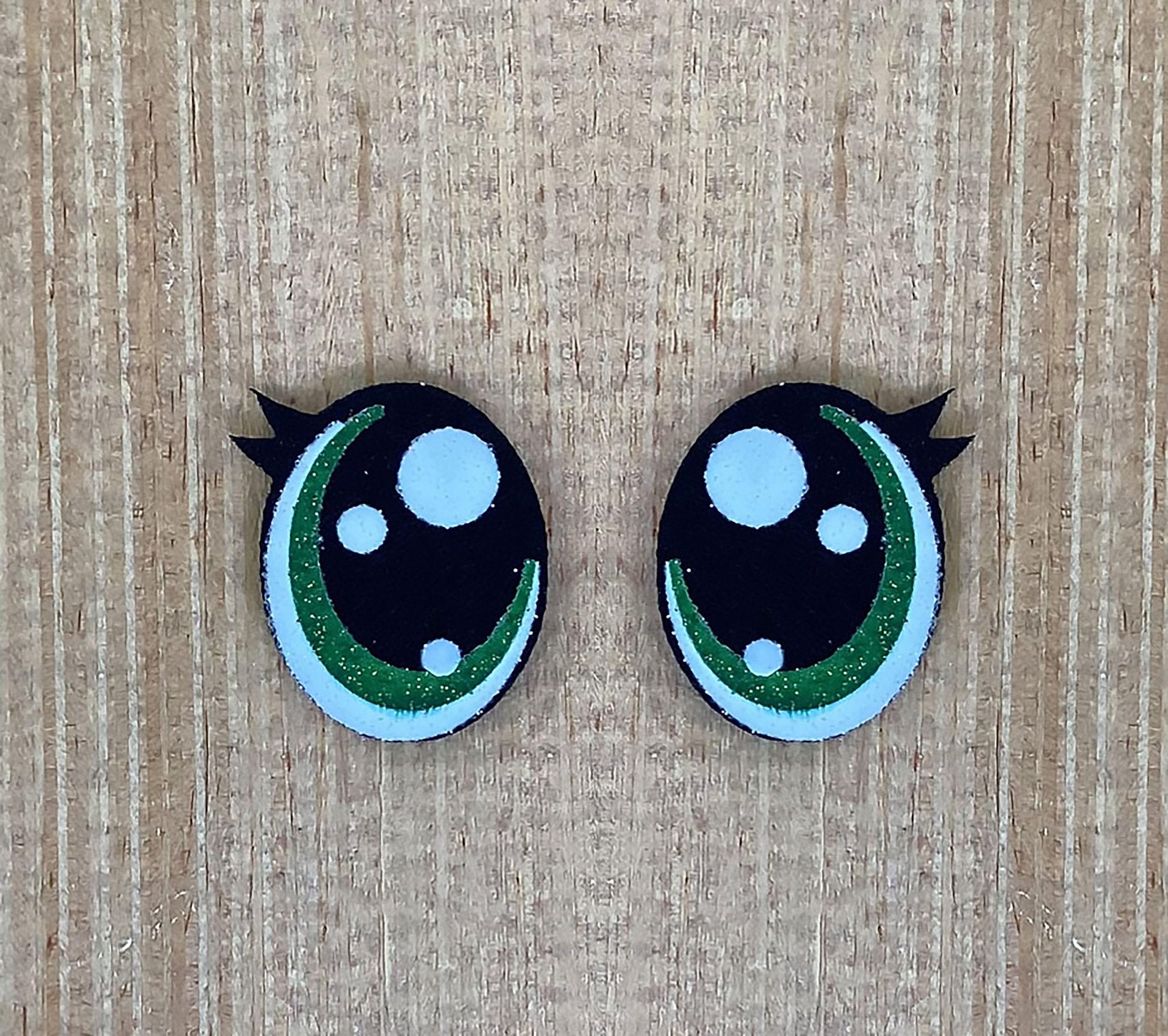 a pair of black and green buttons with white dots