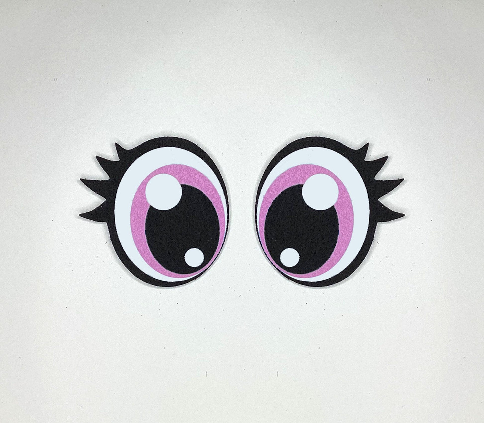 a pair of pink and black eyeballs on a white surface