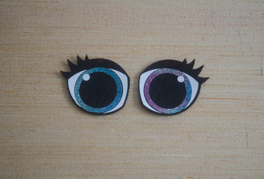 a close up of two fake eyes on a wooden surface